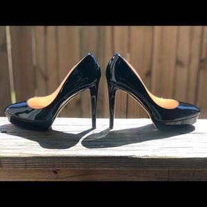 A pair of JIMMY CHOO patent leather black heels.